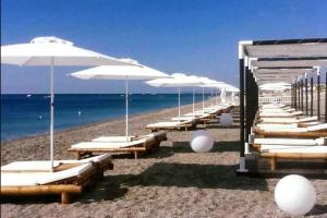 a row of lounge chairs and umbrellas on a beach at Casa di Ida in Locri
