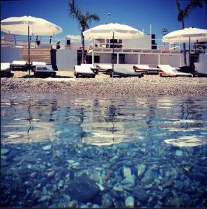 una piscina de agua con sombrillas en una playa en Casa di Ida, en Locri