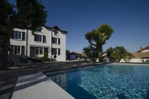 a large swimming pool in front of a house at Villa La Maternite in Villieu