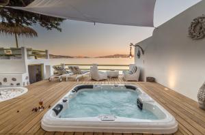 bañera de hidromasaje en una terraza con vistas al océano en villa lord, en Pollonia