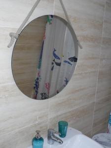 マラガにあるEstudio HCの洗面台の上にバスルームの鏡(シャワーカーテン付)が備わります。