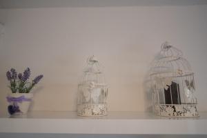 three bird cages sitting on a shelf with a vase at Apartments Braut Krk in Krk