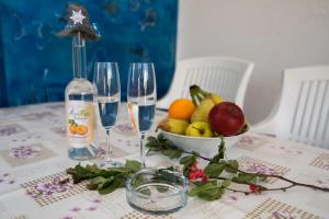 a table with two wine glasses and a bowl of fruit at Apartments Braut Krk in Krk