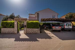 a car parked in a parking lot in front of a house at Apartments Braut Krk in Krk