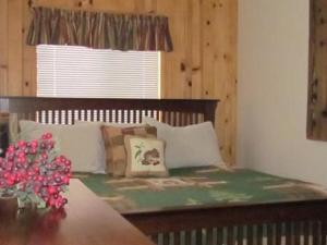 a bedroom with a bed with a table and a window at Cabin on the Corner in Big Bear Lake