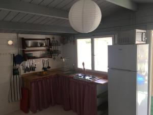 a kitchen with a white refrigerator and a window at Alojamientos la Huella in Los Caños de Meca +49 photos