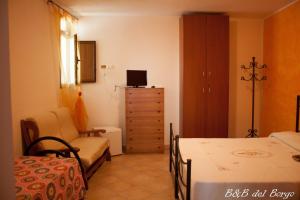 a bedroom with a bed and a chair and a dresser at B&B del Borgo in Laino Borgo