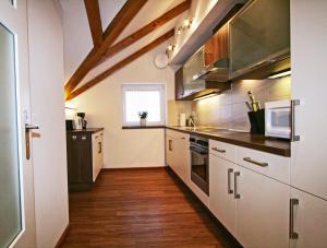 cocina con electrodomésticos de acero inoxidable y suelo de madera en Ferienwohnung Am Kurpark -Wohnung 3,150qm- mit Lift, en Garmisch-Partenkirchen