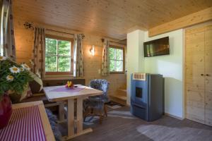 a kitchen with a table and a refrigerator in a room at Chalet Auszeit in Walchsee