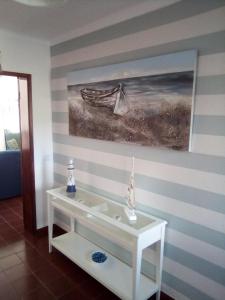 a room with a white table with a painting on the wall at Casa Das Ondas - Praia Do Norte in Nazaré