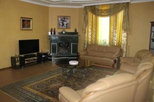 a living room with couches and a television and a fireplace at Green Guest House in Kutaisi