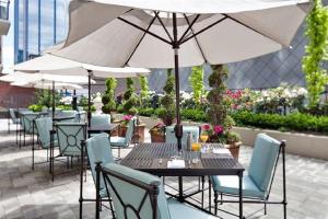 a table with chairs and an umbrella on a patio at L'Hermitage Hotel in Vancouver