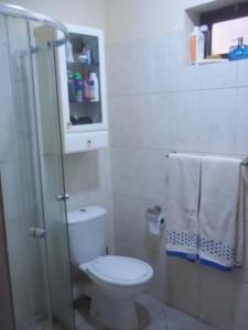 a bathroom with a toilet and a shower and towels at Ap Palmarejo in Praia
