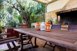 an outdoor wooden table with four jars on it at Aria Apartments in Apolpaina