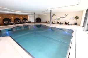 
a swimming pool with a large tub in the middle of it at Hotel Auf der Gsteig GmbH in Lechbruck

