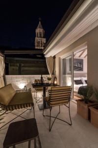 a patio with a table and chairs at night at Murum Heritage Hotel in Split