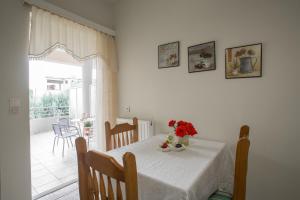 a dining room with a table with flowers on it at Studios Theodore in Kalamata
