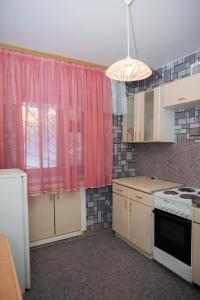 cocina con ventana rosa y fogones en Апартаменты на Курской, en Tyumen