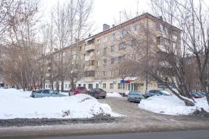 un aparcamiento cubierto de nieve frente a un edificio en Апартаменты на Курской, en Tyumen
