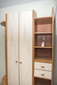 a closet with a wooden cabinet and shelves at Апартаменты на Курской in Tyumen