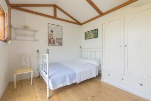 a bedroom with a white bed and a chair at Glamping & Camping Green Istria in Marezige