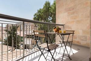 a balcony with a table and two chairs on it at Yafo 35 -Isrentals in Jerusalem