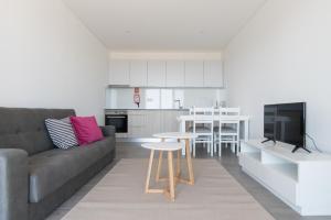 a living room with a couch and a table and a kitchen at Portal dos Vimes AL in Companhia de Cima