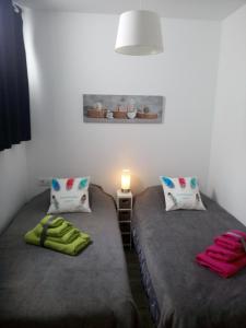 two twin beds in a room with a lamp at Apartment Island Paradise in Adeje +40 photos