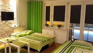 グディニャにあるApartament GDYNIAKのベッドルーム1室(ベッド2台、緑のカーテン付)