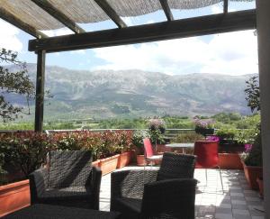 a patio with chairs and a table with mountains in the background at Attico D'Andrea in Pratola Peligna