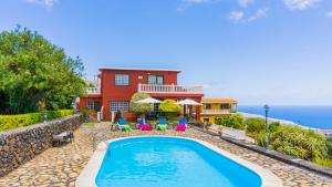 a pool in front of a house with the ocean in the background at La Rivera Apartments in Tenagua