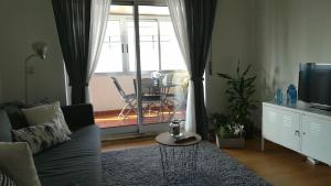 a living room with a couch and a television and a table at Liberdadeflat4u in Braga