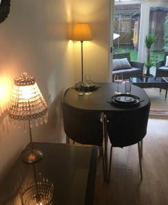una mesa con copas de vino y una lámpara en una habitación en One bedroom house in pretty Oxfordshire village - super fast broadband, en Didcot