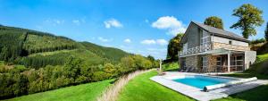 une maison sur une colline avec une piscine dans l'établissement Le Rêve d'Elise, à Stoumont