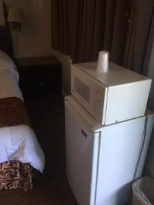 a microwave on top of a refrigerator in a room at Frontier Motel in Anaheim