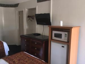 Habitación con microondas en la parte superior de una cómoda en Frontier Motel en Anaheim