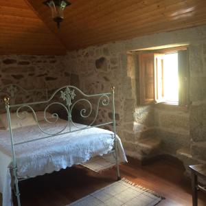 um quarto com uma cama num quarto com uma janela em Refugio dos Cregos em Riba de Mouro
