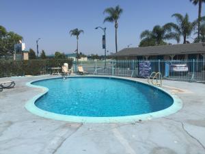 una pequeña piscina con agua azul en un patio en Frontier Motel, en Anaheim