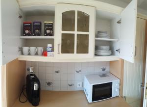 a kitchen with white cabinets and a microwave at Sanosueno 2 in Sonthofen