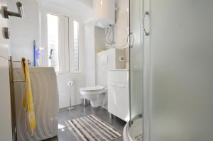 a white bathroom with a toilet and a sink at Studio Ana Carera in Rovinj