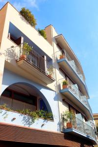 un edificio blanco con balcones y macetas en Hotel Carmen en Rosas