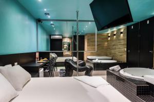 a bedroom with a bed and a bathroom with a tub at Ouro Motel in Sepetiba