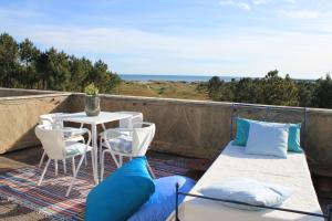 a balcony with a table and chairs and the ocean at Sea House in Viana do Castelo