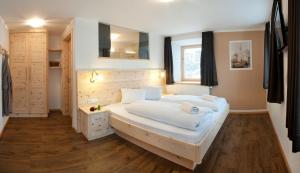 a bedroom with a large white bed and a window at Hotel Hofer in San Valentino alla Muta