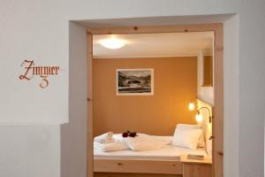 a bedroom with a bed with a mirror in it at Hotel Hofer in San Valentino alla Muta