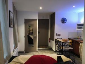een slaapkamer met een bed en een keuken met een tafel bij Lulu Philippe in Saint-Étienne