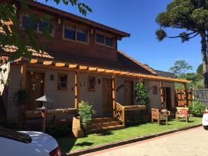 a wooden house with a porch and a yard at Cabanas Belo Destino in Gramado