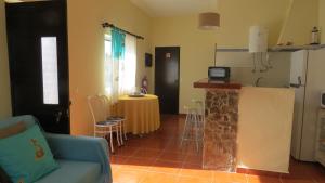 a living room with a blue couch and a kitchen at Casa Barroca in Carrapateira