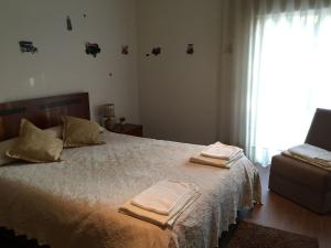 una camera da letto con un grande letto con asciugamani di Turismo Homes River House Mill Gerês a Póvoa de Lanhoso