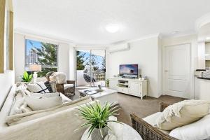 uma sala de estar com um sofá e uma televisão em The Ritz Resort Heated Pool em Gold Coast